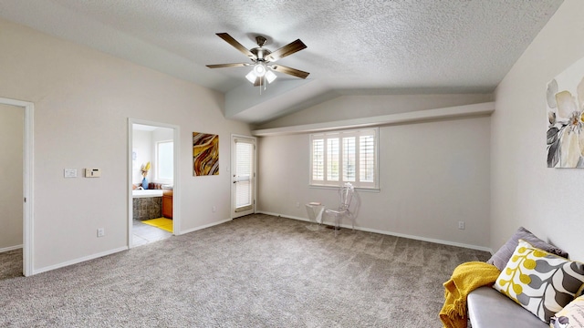 unfurnished bedroom with ensuite bathroom, vaulted ceiling, light colored carpet, and ceiling fan