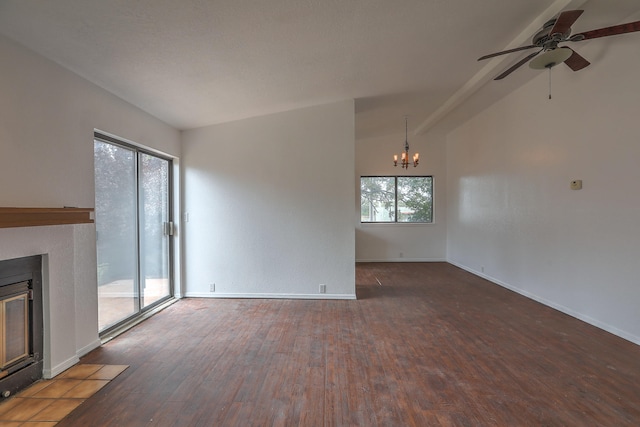 unfurnished living room featuring dark wood-type flooring, ceiling fan with notable chandelier, and vaulted ceiling