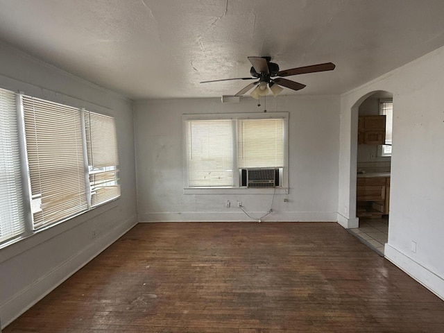 spare room with ceiling fan, plenty of natural light, a textured ceiling, and dark hardwood / wood-style flooring