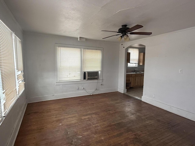 unfurnished living room featuring dark wood-type flooring, ceiling fan, sink, and a wealth of natural light