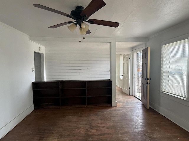 unfurnished room with ceiling fan, crown molding, dark wood-type flooring, and a textured ceiling