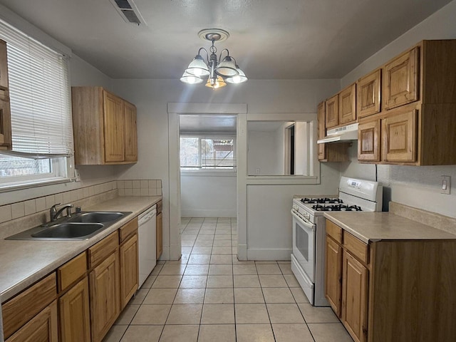 kitchen featuring sink, a wealth of natural light, white appliances, and decorative light fixtures