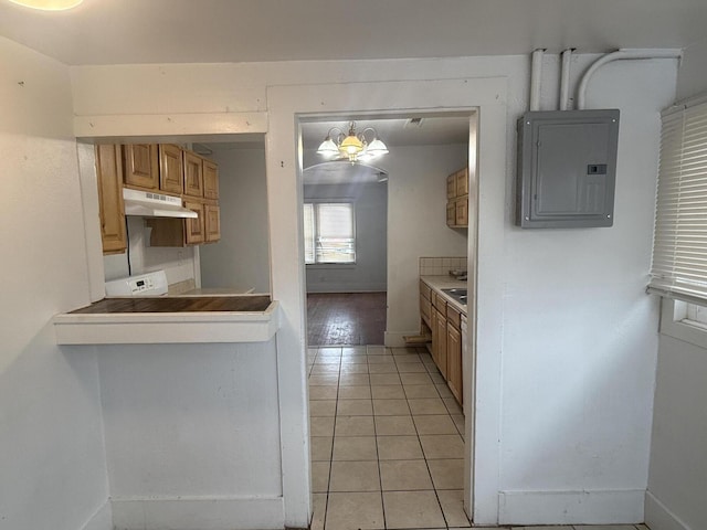 kitchen featuring electric panel, a chandelier, and light tile patterned flooring