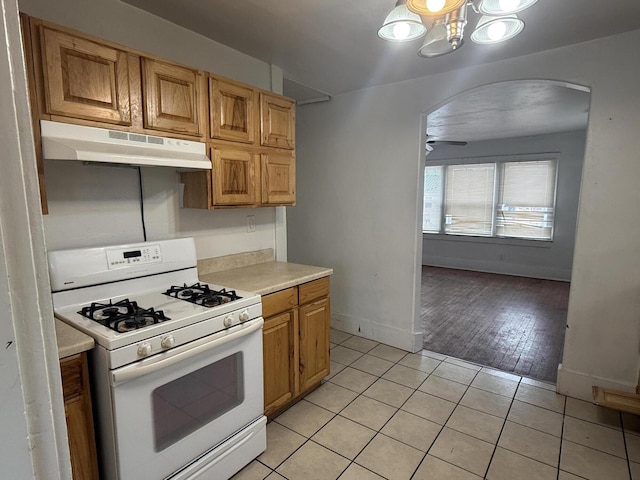 kitchen with light tile patterned floors and white gas range oven