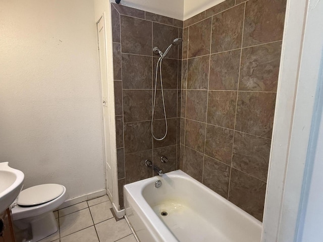 bathroom with tile patterned flooring, tiled shower / bath combo, and toilet