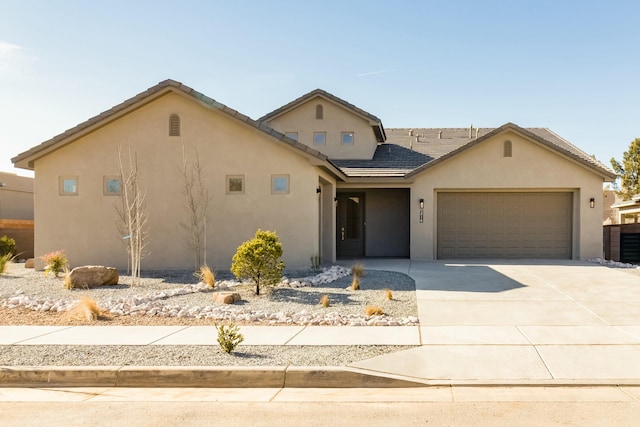 view of front facade with driveway, stucco siding, and an attached garage