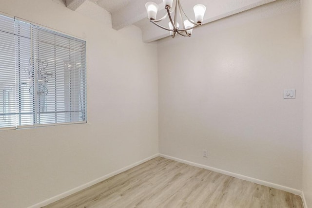 unfurnished room featuring an inviting chandelier, beam ceiling, and light hardwood / wood-style floors