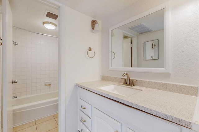 bathroom with tiled shower / bath, tile patterned floors, and vanity