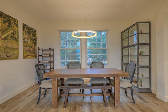 dining space featuring baseboards and light wood-style floors