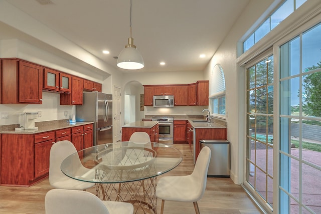 kitchen featuring light wood finished floors, a center island, stainless steel appliances, a sink, and recessed lighting