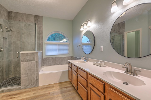 full bath featuring a garden tub, wood finished floors, a sink, and a shower stall