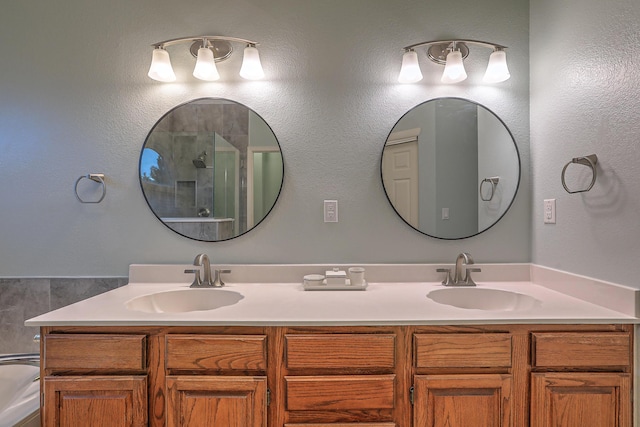 full bathroom featuring double vanity, a sink, and a shower with shower door