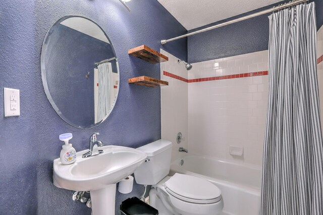 bathroom featuring shower / bath combo, a textured wall, a textured ceiling, and toilet