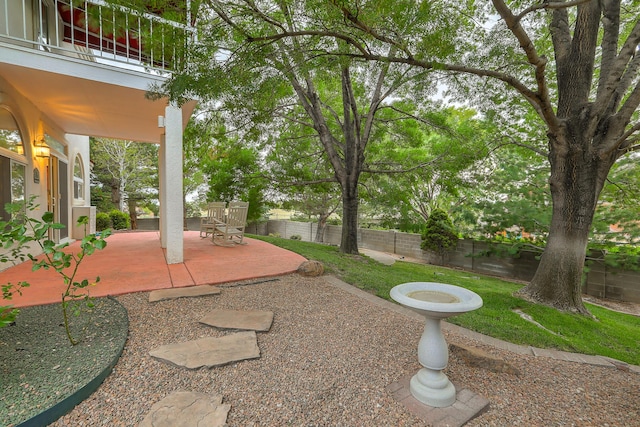 view of yard with a patio area, fence private yard, and a balcony