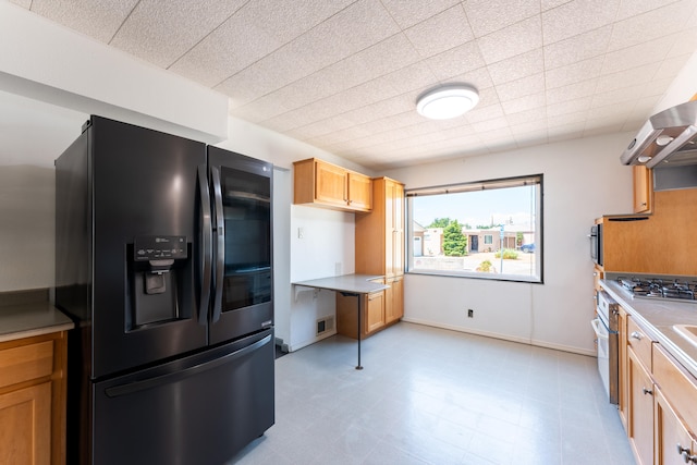 kitchen featuring stainless steel gas stovetop and refrigerator with ice dispenser