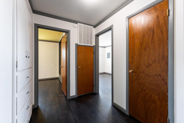 hallway with dark hardwood / wood-style floors and crown molding