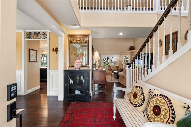 foyer entrance featuring crown molding and dark wood-type flooring