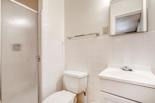 bathroom with an enclosed shower, vanity, toilet, and tile walls