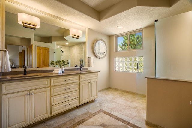 bathroom featuring tile patterned flooring, walk in shower, a textured ceiling, and vanity