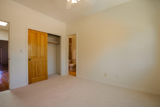 unfurnished bedroom with a closet, ceiling fan, connected bathroom, and carpet floors