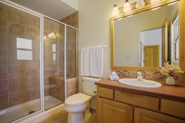 bathroom with toilet, tile patterned flooring, a shower with door, vanity, and a textured ceiling