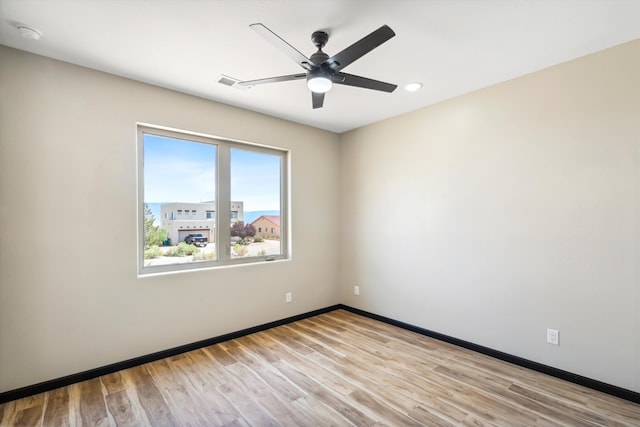 empty room featuring ceiling fan and light hardwood / wood-style floors