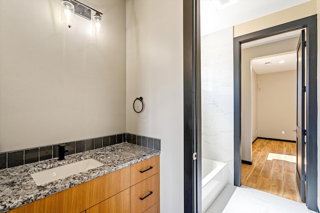 bathroom featuring a tub, hardwood / wood-style floors, and vanity