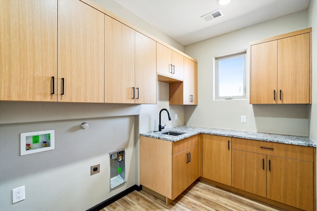 kitchen featuring light stone counters, light hardwood / wood-style floors, and sink