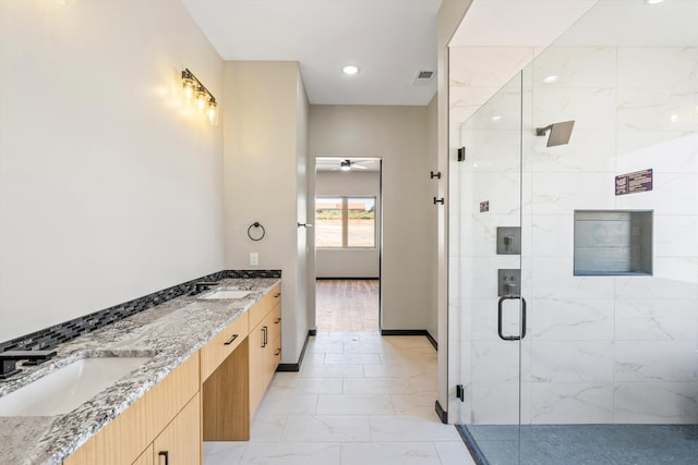 bathroom with a shower with shower door, ceiling fan, and vanity