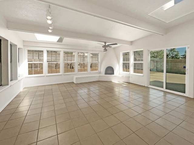 unfurnished sunroom featuring a healthy amount of sunlight, ceiling fan, and lofted ceiling with beams