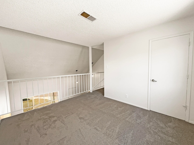 carpeted spare room with a textured ceiling