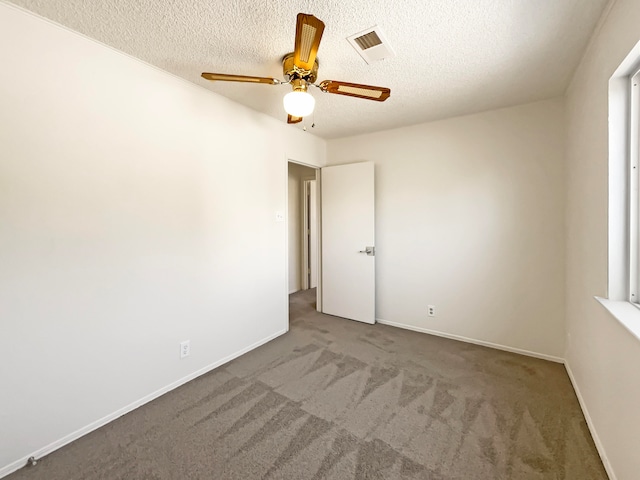 carpeted empty room featuring a textured ceiling and ceiling fan