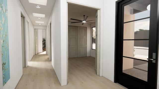 hall featuring a skylight and light hardwood / wood-style floors