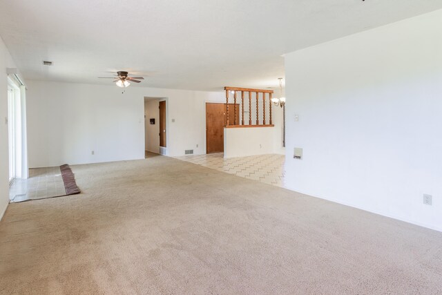 unfurnished living room with light carpet and ceiling fan with notable chandelier