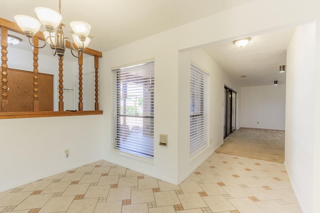 hall with light colored carpet and a notable chandelier