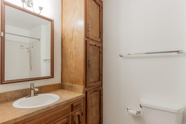 bathroom featuring walk in shower, vanity, and toilet