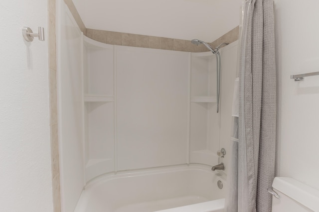 bathroom featuring shower / tub combo and toilet