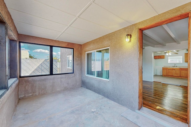 unfurnished sunroom with ceiling fan and sink