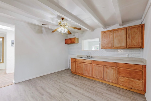 kitchen with beam ceiling, ceiling fan, sink, light hardwood / wood-style flooring, and backsplash