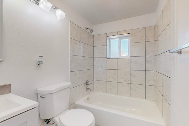 full bathroom featuring vanity, tiled shower / bath combo, and toilet