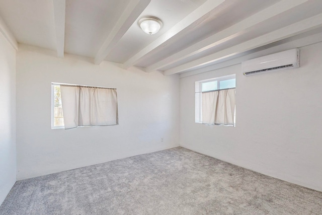 spare room with beam ceiling, light colored carpet, and a wall unit AC