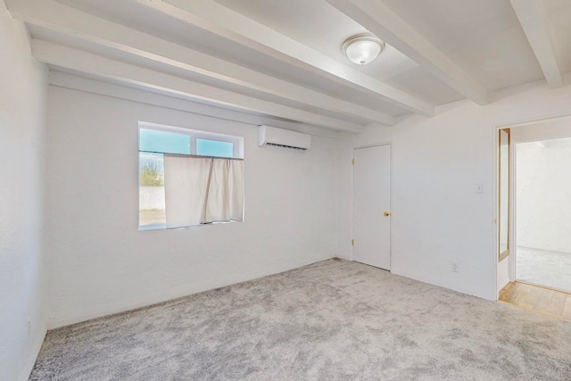 spare room with a wall mounted air conditioner, light colored carpet, and beamed ceiling