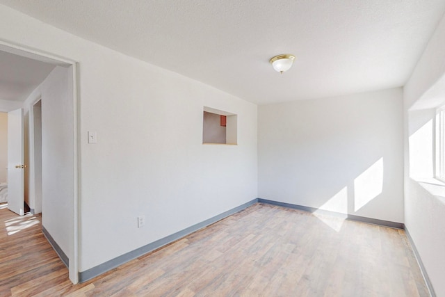 spare room featuring hardwood / wood-style floors and a textured ceiling