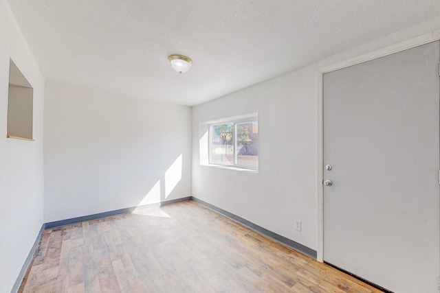 spare room with light hardwood / wood-style flooring and a textured ceiling