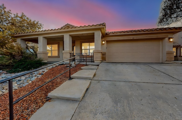 view of front of property with covered porch and a garage