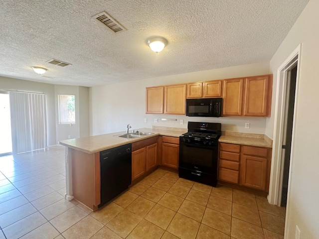 kitchen with a textured ceiling, light tile patterned floors, black appliances, kitchen peninsula, and sink