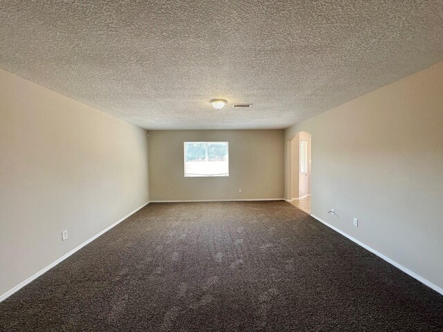 carpeted spare room featuring a textured ceiling