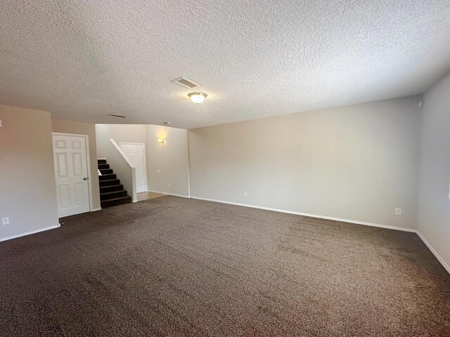 carpeted empty room with a textured ceiling