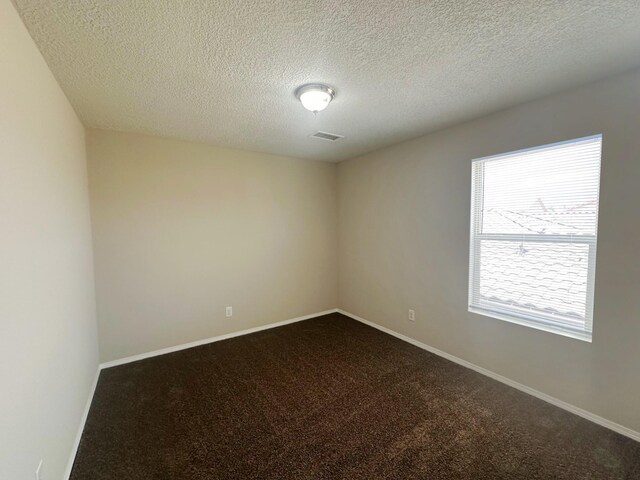 carpeted spare room with a textured ceiling