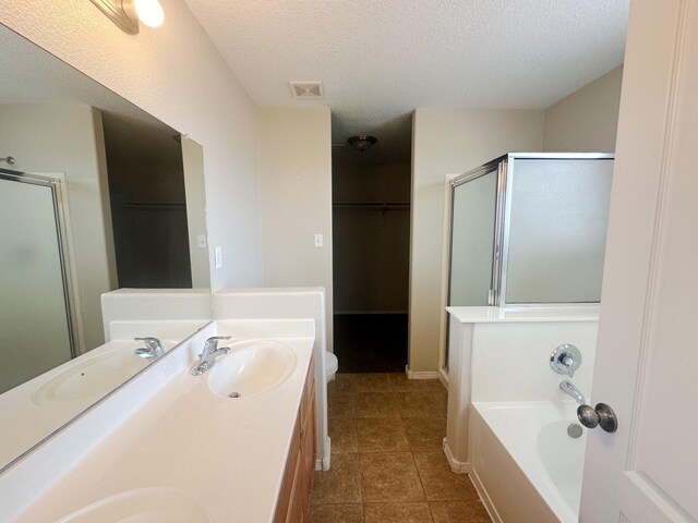 bathroom featuring tile patterned floors, separate shower and tub, a textured ceiling, and vanity